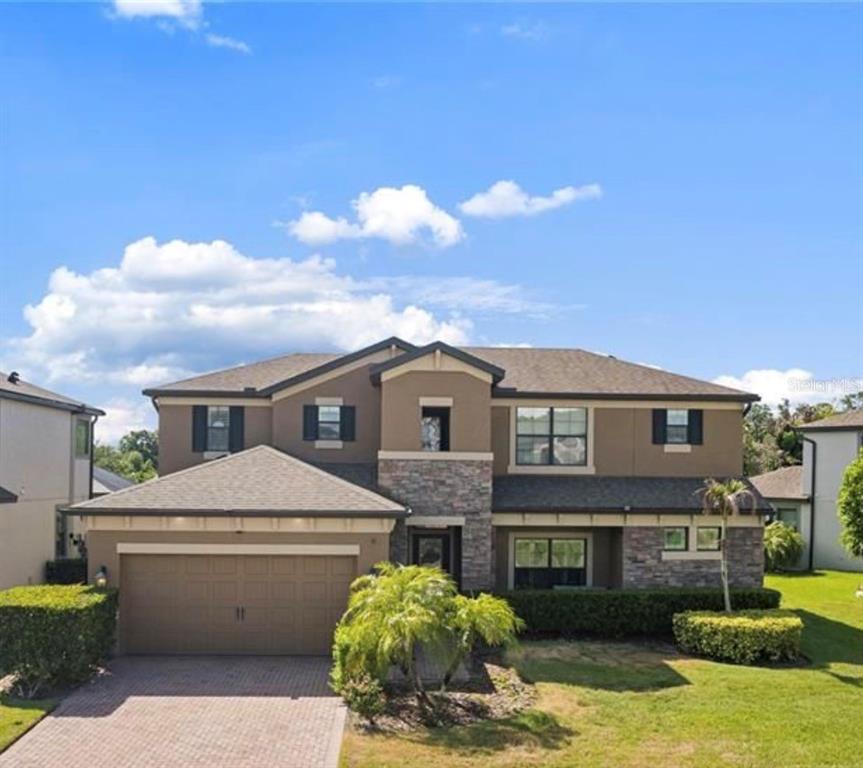 An outdoor kitchen with a stainless steel grill, stone veneer base, and granite countertops — 743 WELLINGTON COURT, OLDSMAR, FL