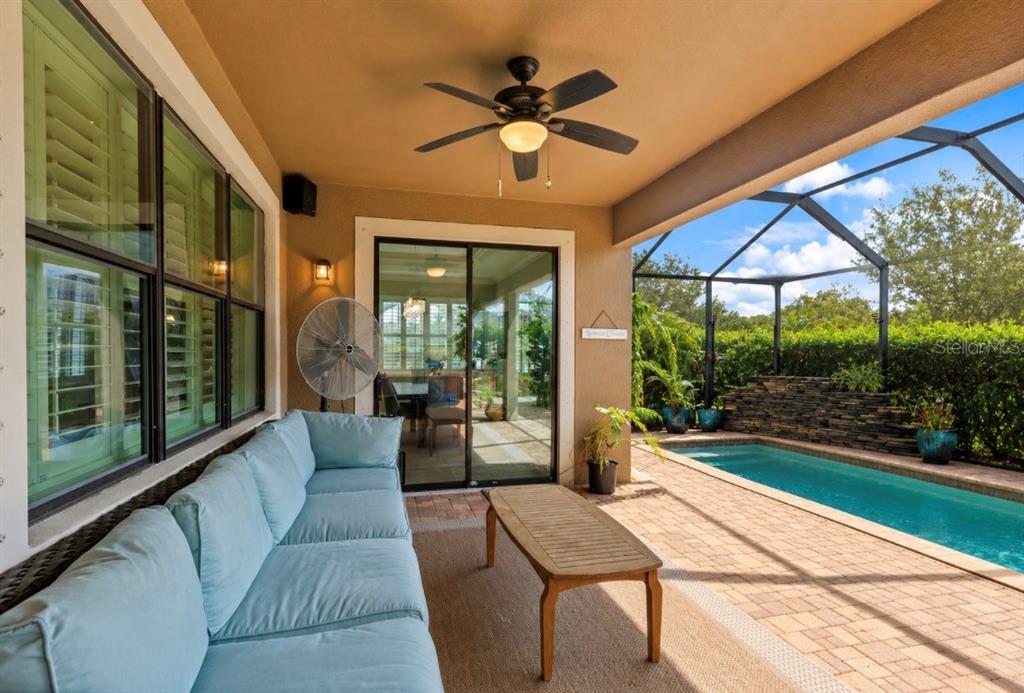 An open-concept living area features a kitchen with dark cabinets, a dining space, and a television — 743 WELLINGTON COURT, OLDSMAR, FL