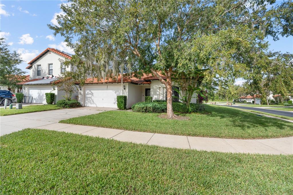 A single-story residential house with a white exterior, tile roof, and a two-car garage — 16813 LAZY BREEZE LOOP, CLERMONT, FL