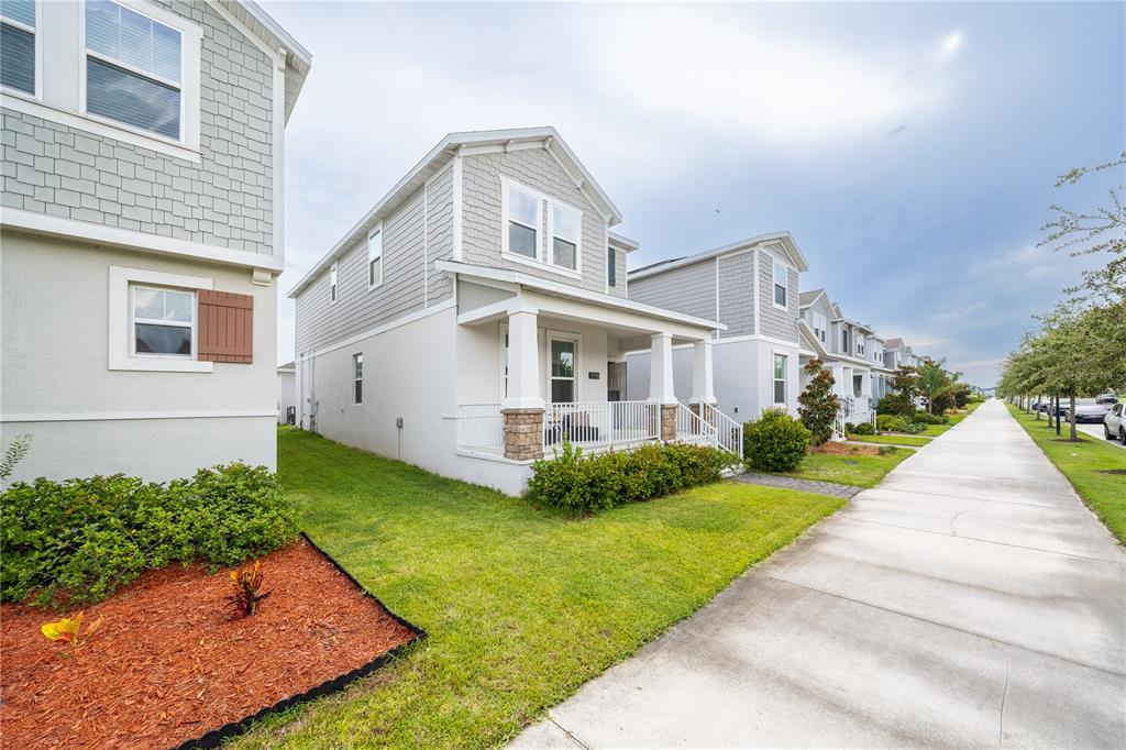 A row of two-story houses with light-colored siding and front porches lines a sidewalk — 1596 CROSS PRAIRIE PARKWAY, KISSIMMEE, FL