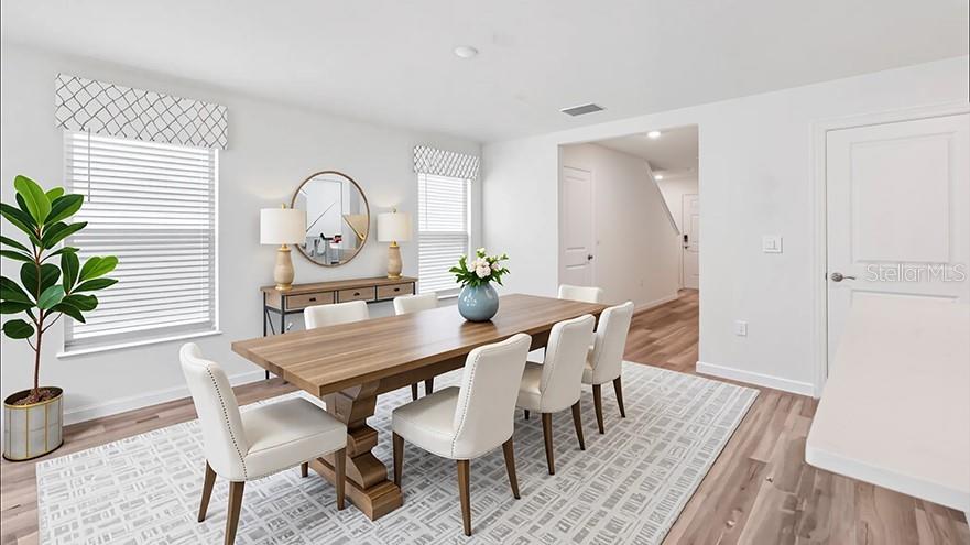 A dining room features a wooden table, white chairs, a patterned rug, and two windows — 2106 NE 33RD LANE, OCALA, FL