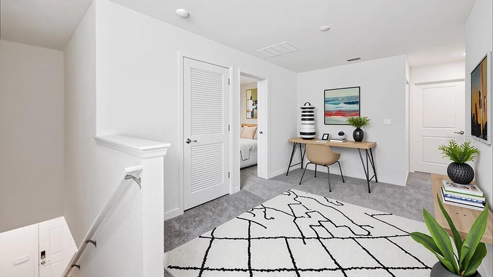 A carpeted loft area features a desk, a patterned rug, and a doorway to a bedroom — 2106 NE 33RD LANE, OCALA, FL