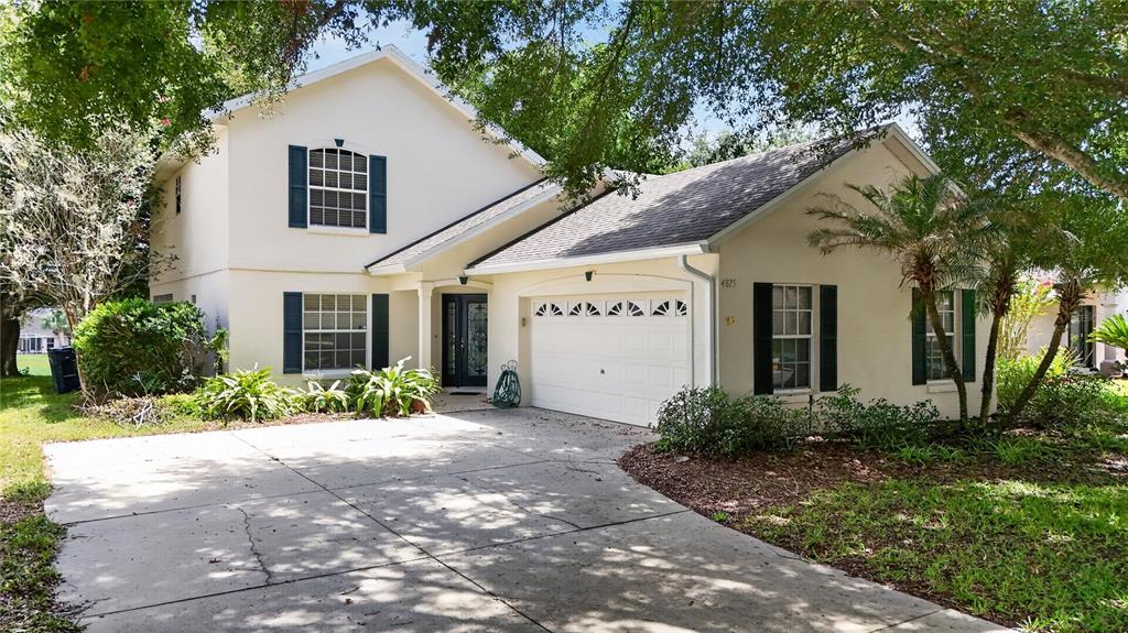 A two-story house with a white stucco exterior, blue shutters, and a two-car garage — 4875 ABACO DRIVE, TAVARES, FL