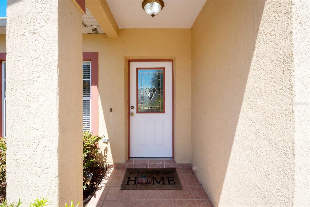 A front entryway features a white door with a decorative glass insert and tile flooring — 526 MARICOPA DRIVE, KISSIMMEE, FL