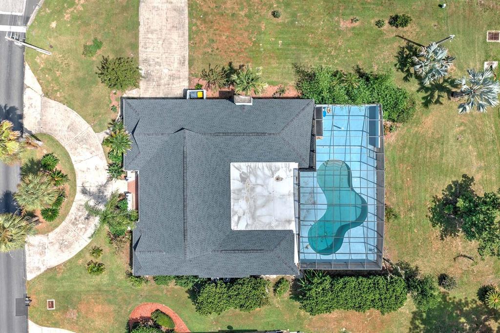 An aerial view shows a house with a dark shingled roof and a screened-in pool — 4012 SUNRISE DRIVE, SEBRING, FL