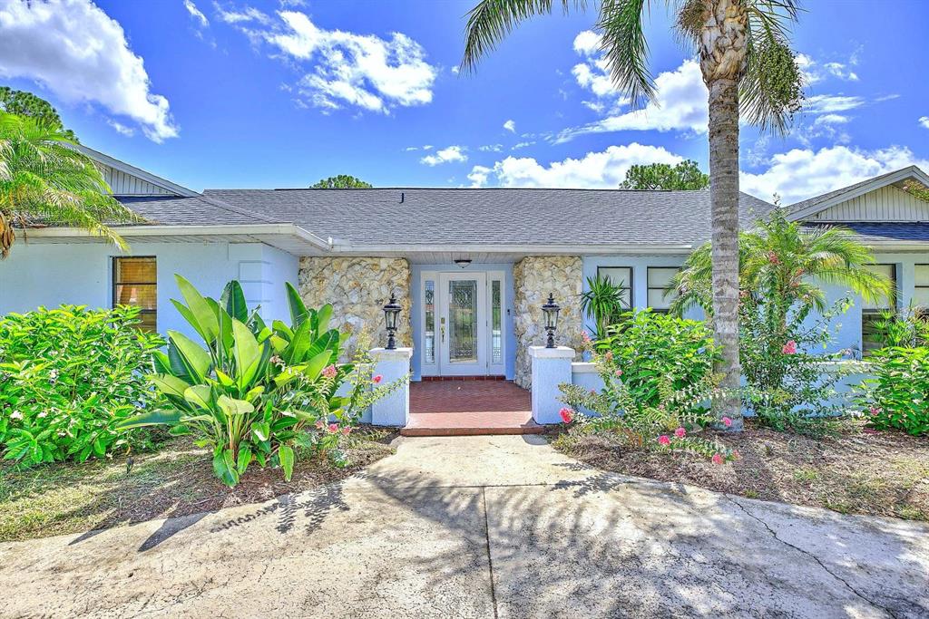 A single-story house with a stone facade, white trim, and a brick-paved entryway — 4012 SUNRISE DRIVE, SEBRING, FL
