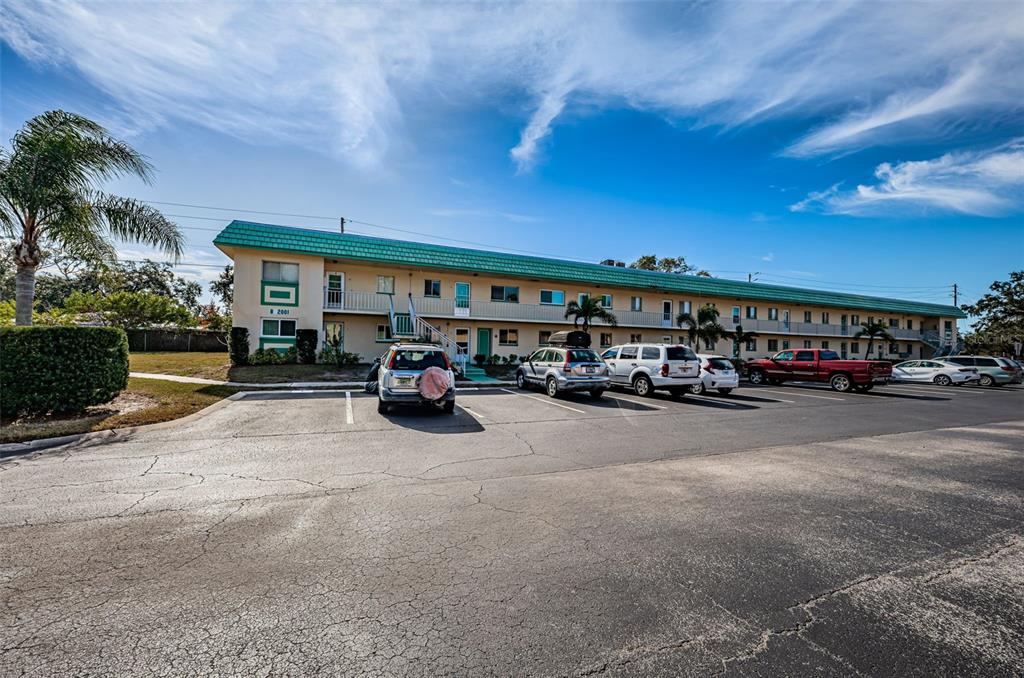 A multi-story apartment building with a green roof and a parking lot in front — 2001 GREENBRIAR BOULEVARD UNIT 6, CLEARWATER, FL