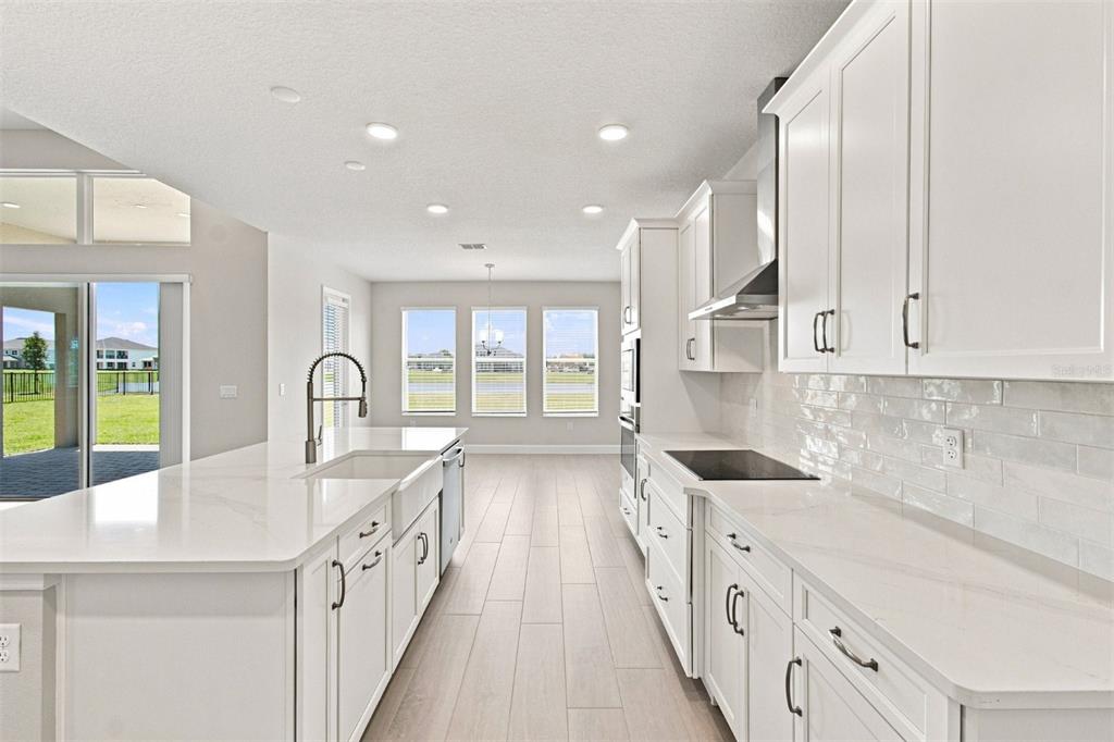 An unfinished interior space features white walls, recessed lighting, and floors covered in protective paper — 17036 OVERSTORY ROAD, ORLANDO, FL