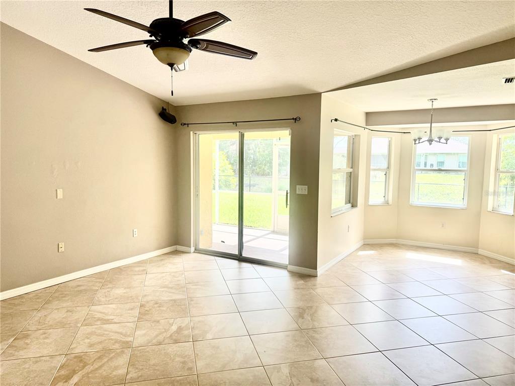 A living room with tile flooring, a ceiling fan, and sliding doors leading outside — 2043 OLD TRENTON LANE, SARASOTA, FL