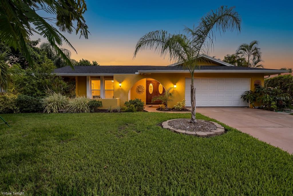 A yellow single-story house with a white garage door and a palm tree in front — 11555 PINE STREET, SEMINOLE, FL