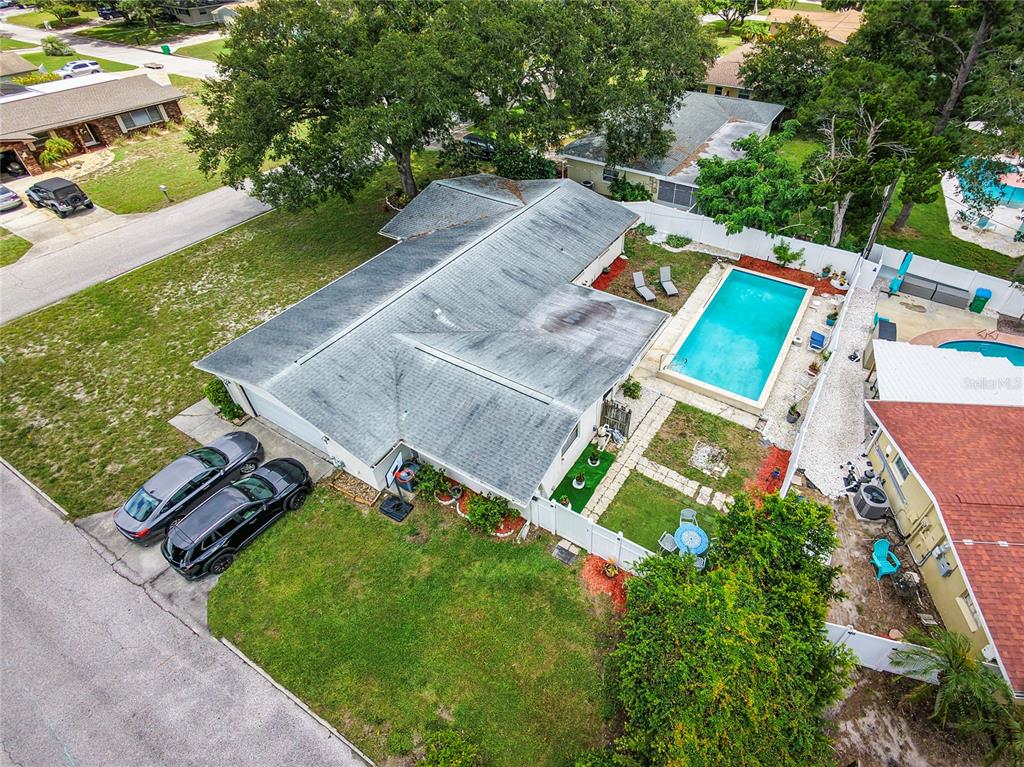 An aerial view shows a house with a swimming pool and two cars parked outside — 1901 STANCEL DRIVE, CLEARWATER, FL