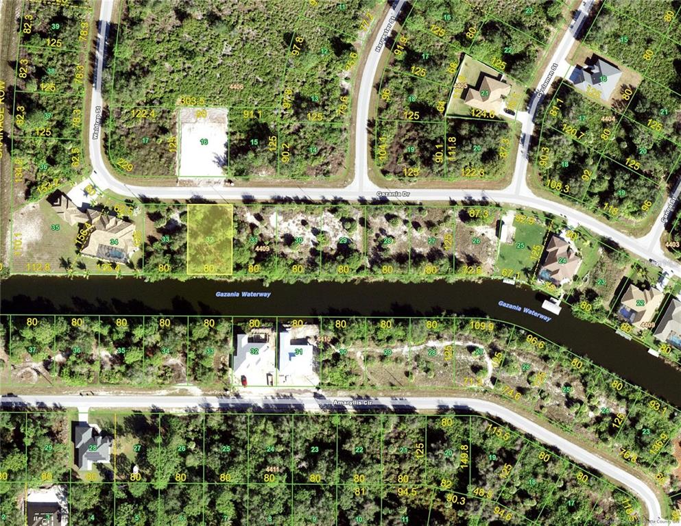 An aerial view shows a rectangular plot of land bordering a body of water — 9602 GAZANIA DRIVE, PORT CHARLOTTE, FL