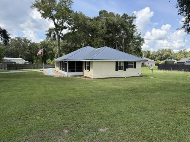 A single-story house with a metal roof and a screened-in porch overlooks a grassy yard — 300 SW BRIGHTON COURT, FORT WHITE, FL