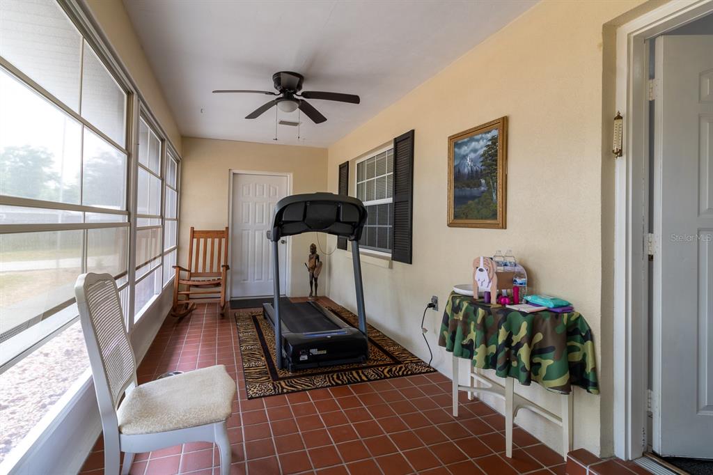 A single-story house with a metal roof and a detached garage sits on a lawn — 300 SW BRIGHTON COURT, FORT WHITE, FL