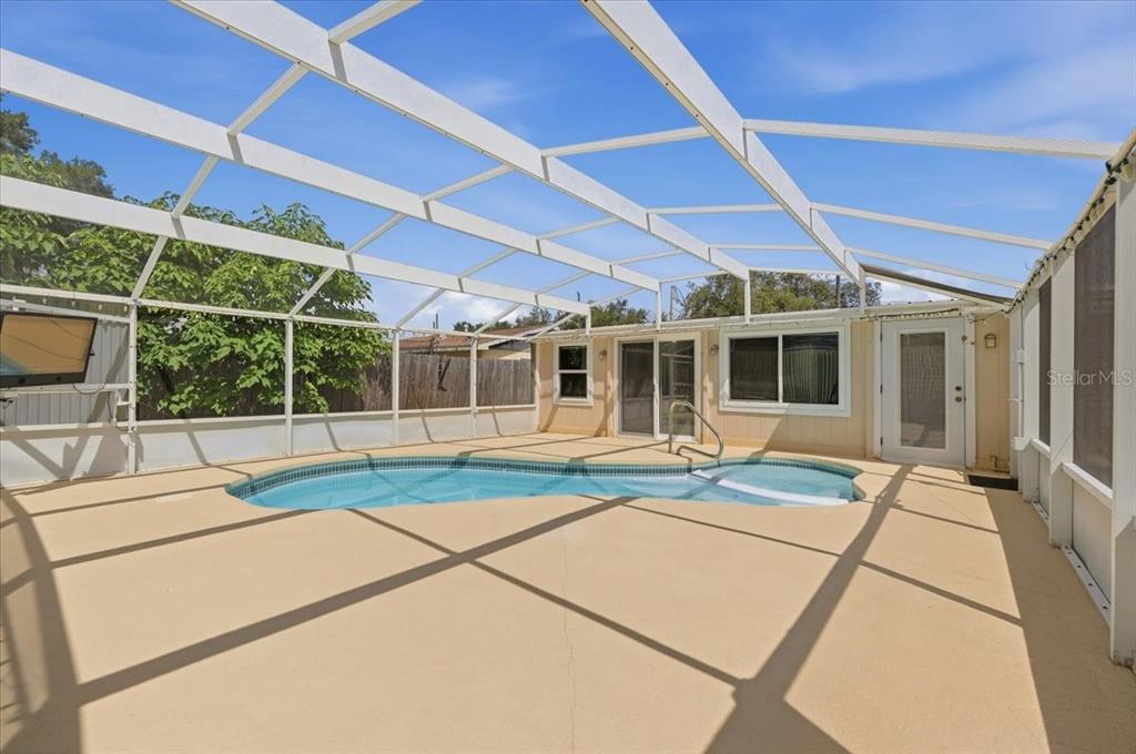 A single-story, light-colored house with a concrete driveway and a grassy front yard — 122 W COLLINS STREET, LAKELAND, FL