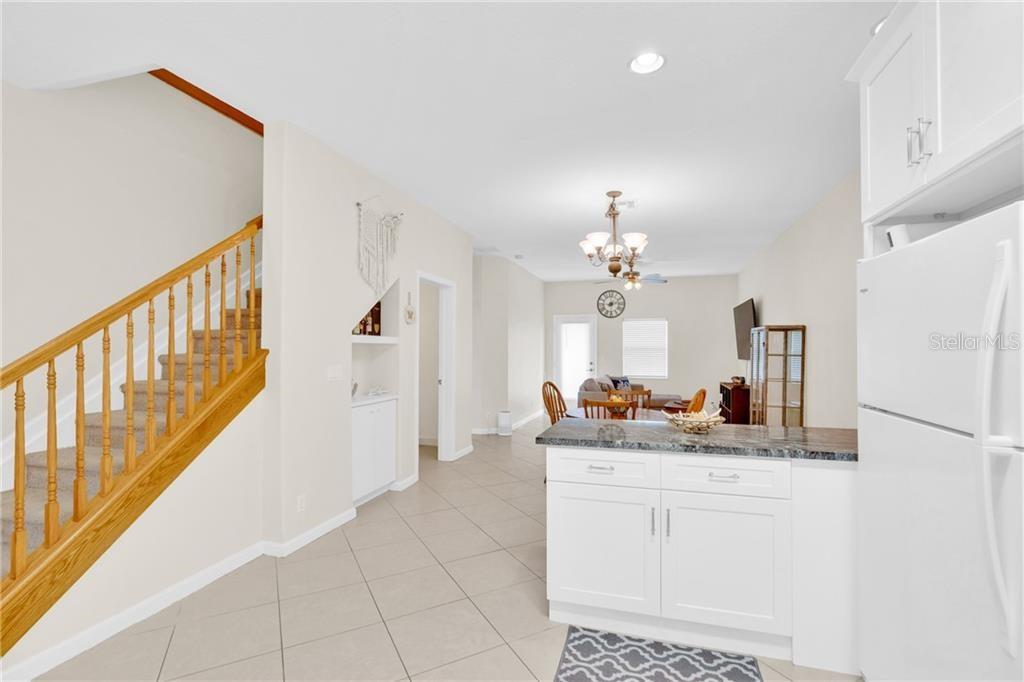 A kitchen island overlooks a living area with a staircase on the left — 1917 77TH DRIVE, VERO BEACH, FL