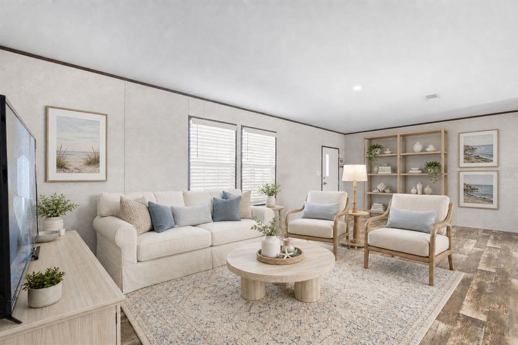 A living room with a sofa, two armchairs, a coffee table, and a wooden bookshelf — 224 WOLVERINE AVENUE, NORTH PORT, FL