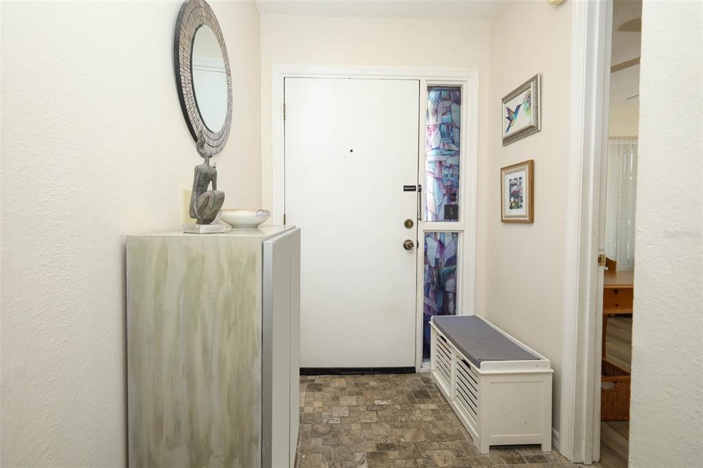 A foyer features a white front door with stained glass, a bench, and a mirror — 2372 SUN VALLEY CIRCLE UNIT 2372, WINTER PARK, FL