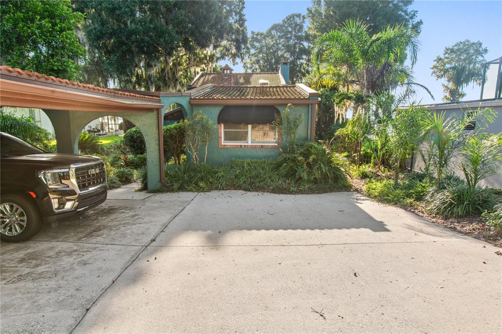 A teal-colored house with a brick chimney and a landscaped yard with a birdbath — 1019 W LAKE ELOISE TERRACE, WINTER HAVEN, FL