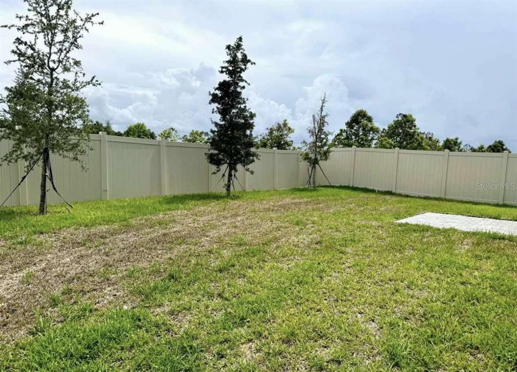 A single-story blue house features a two-car garage and a paved driveway — 522 FELTRIM MANOR ROAD, HAINES CITY, FL