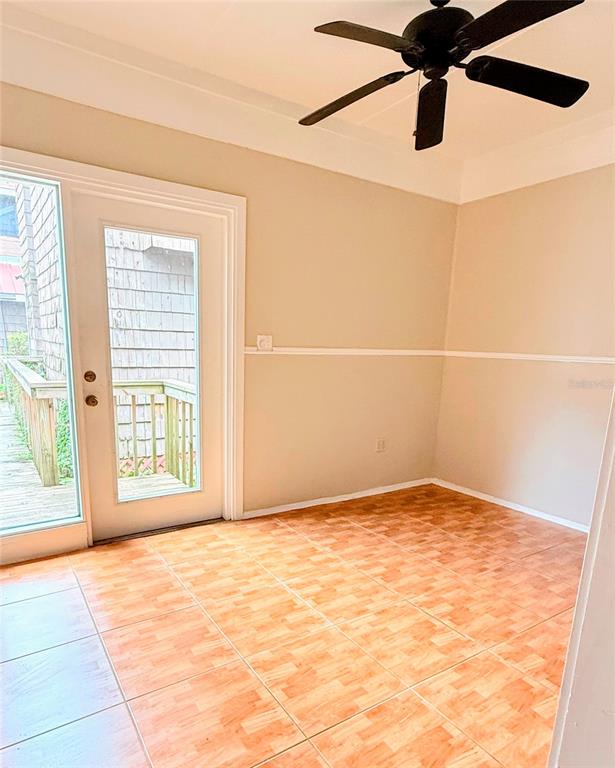 A room with light-colored walls, a ceiling fan, tiled flooring, and a glass door to a deck — 808 NW 23RD AVENUE, GAINESVILLE, FL