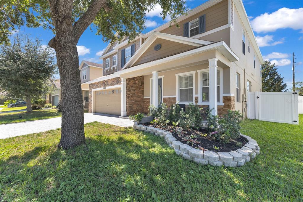 A two-story house with a stone-accented facade, a two-car garage, and a paved driveway — 10030 STRATFORD POINTE AVENUE, ORLANDO, FL