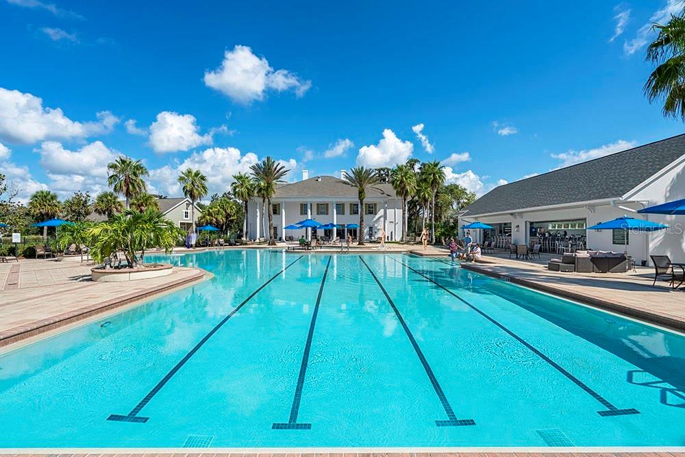 A large outdoor swimming pool with lap lanes sits in front of a white building — 4700 SOUTHERN VALLEY LOOP, BROOKSVILLE, FL