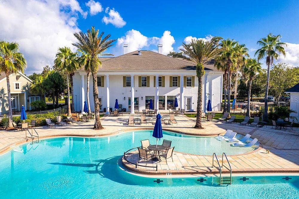 A large white building with columns overlooks a swimming pool with a central seating area — 4700 SOUTHERN VALLEY LOOP, BROOKSVILLE, FL
