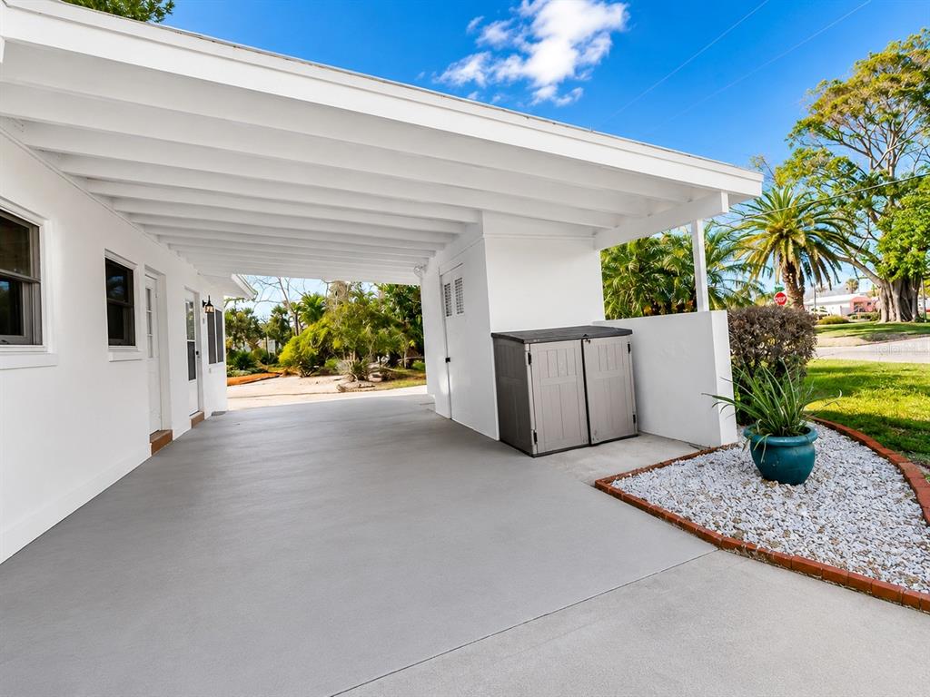 A white single-story house features a concrete driveway, a small covered patio, and a lawn — 301 41ST AVENUE, ST PETE BEACH, FL