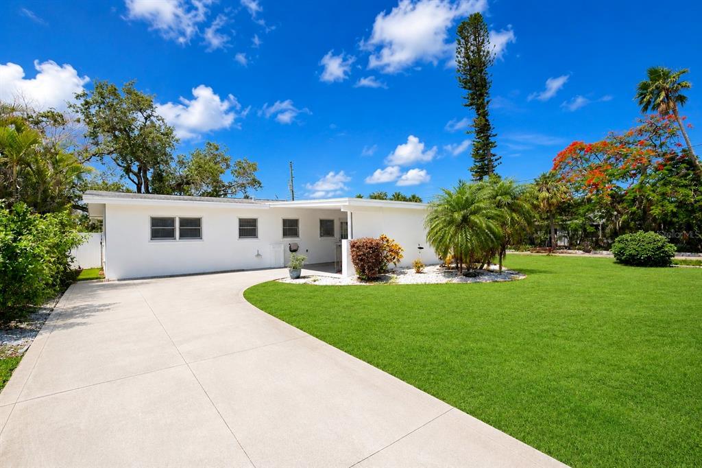 A white house with a screened-in patio and a large tree in the backyard — 301 41ST AVENUE, ST PETE BEACH, FL