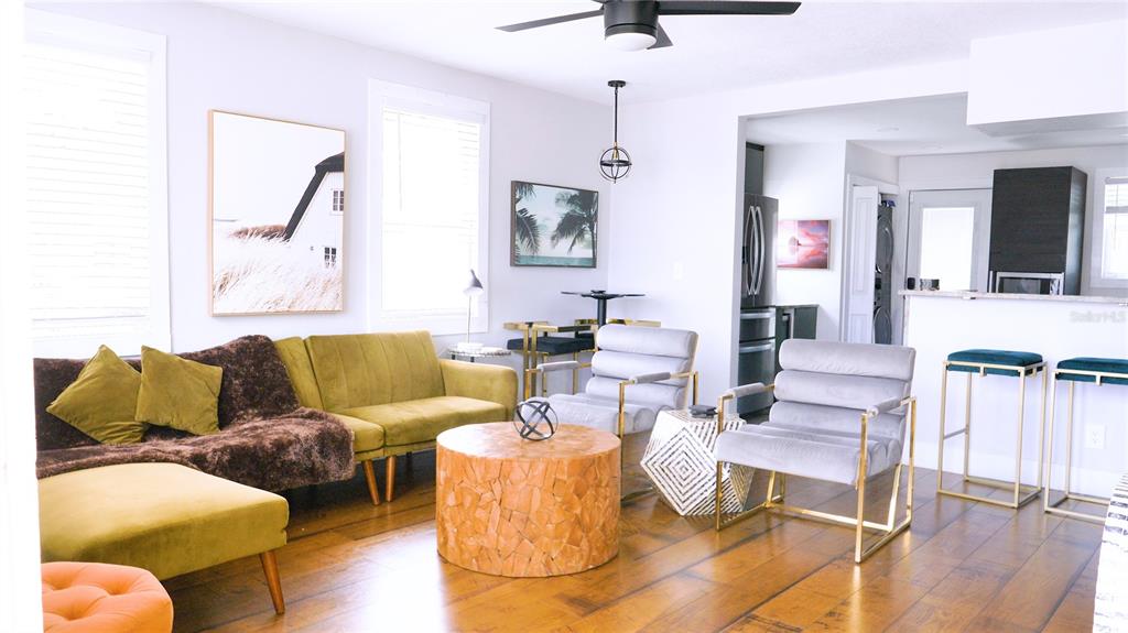 A living room features a green sofa, two grey chairs, and a wooden coffee table — 121-123 N HOLLYWOOD AVENUE, DAYTONA BEACH, FL