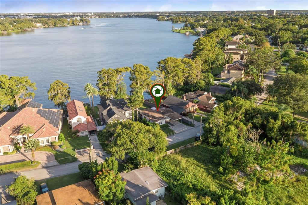An aerial view shows a house with a red marker located near a large lake — 560 OLOLU DRIVE, WINTER PARK, FL