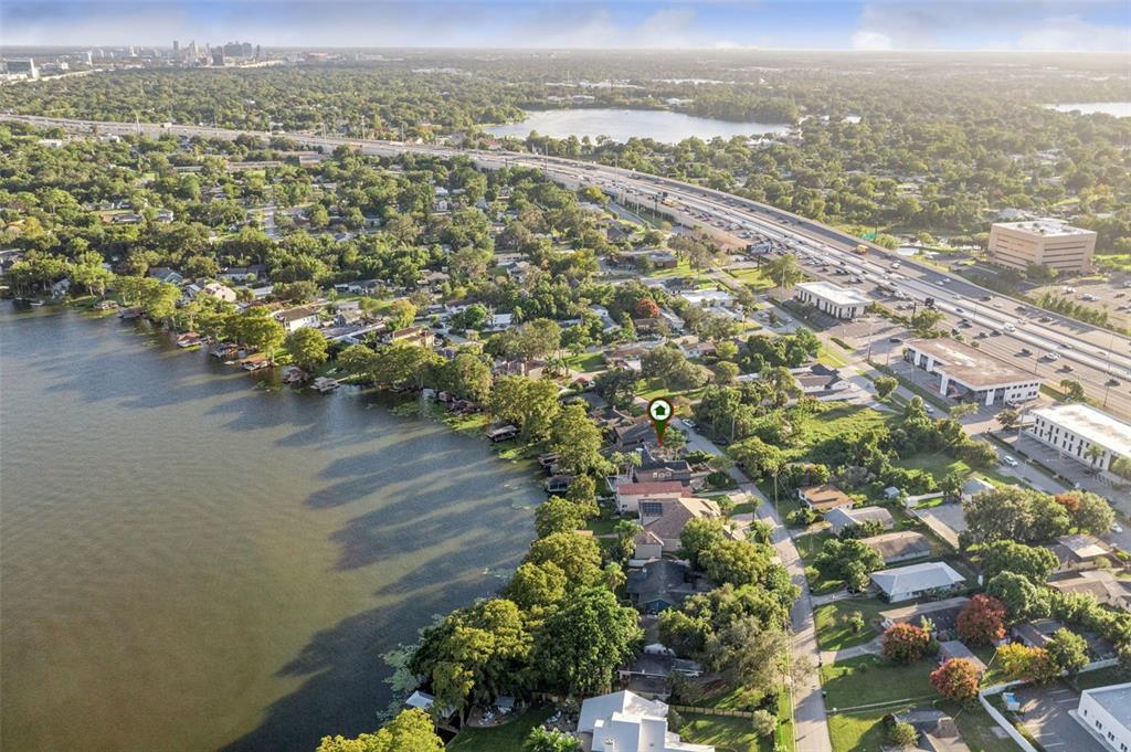 An aerial view shows a residential neighborhood with houses situated along a lakefront — 560 OLOLU DRIVE, WINTER PARK, FL