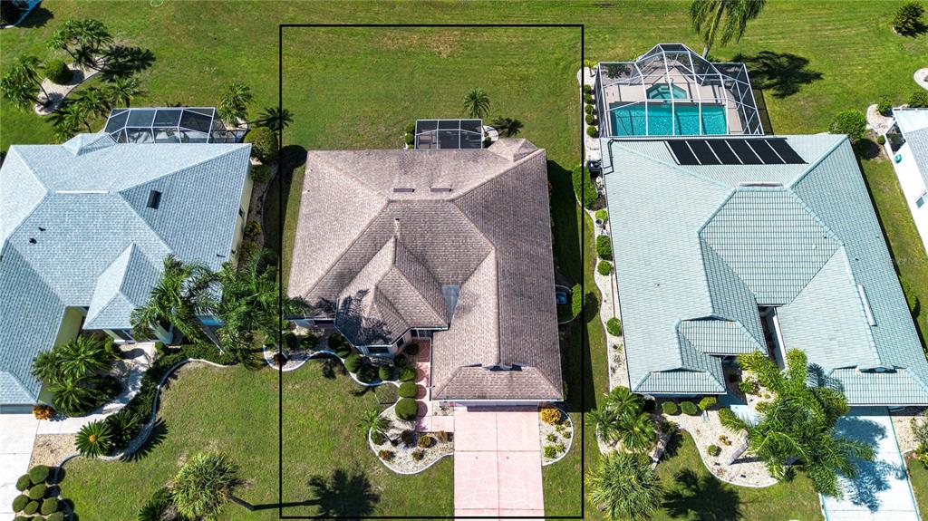 An aerial view shows a single-story house with a brown roof and a large backyard — 2424 E DEL WEBB BOULEVARD, SUN CITY CENTER, FL
