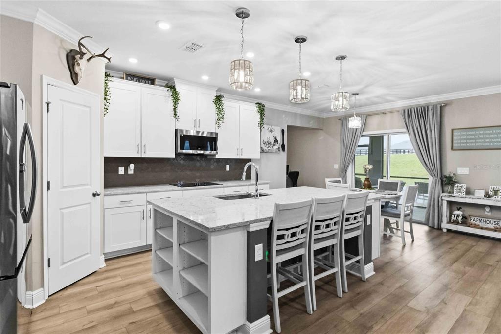 A living room features a stone fireplace, a large sectional sofa, and light wood flooring — 10007 DOLPHIN GULL CIRCLE, THONOTOSASSA, FL