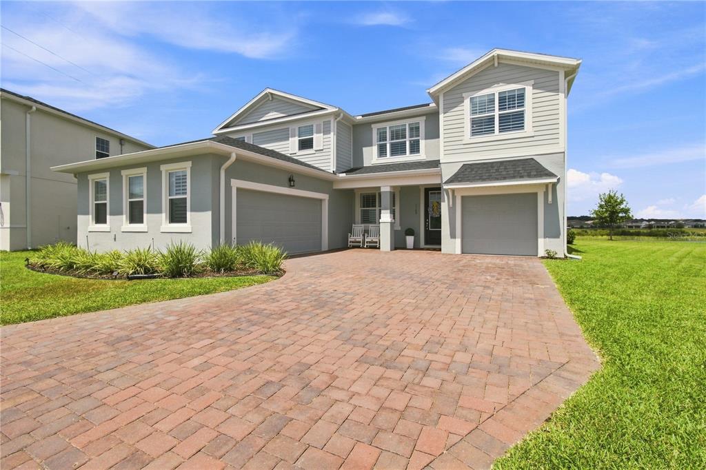 A two-story gray house with a single-car garage and a paved driveway — 3168 CANNA LILY PLACE, CLERMONT, FL