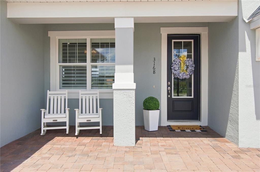 A two-story house with a paved driveway, two garages, and light gray siding — 3168 CANNA LILY PLACE, CLERMONT, FL