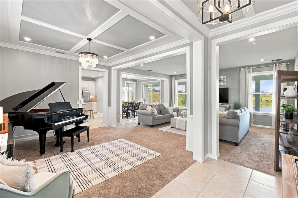 A front porch features two white rocking chairs, a potted plant, and a dark door — 3168 CANNA LILY PLACE, CLERMONT, FL