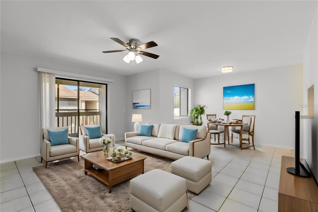 A living room with a beige sofa, two armchairs, a coffee table, and a dining area — 1040 S BUENA VISTA DRIVE UNIT 1040, LAKE ALFRED, FL