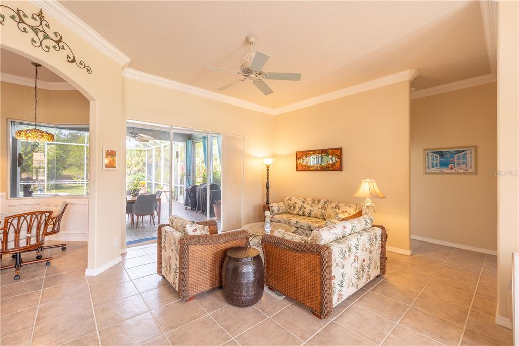 A dining room features a glass-topped table, upholstered chairs, a chandelier, and tile flooring — 1626 E GATE DANCER CIRCLE, INVERNESS, FL