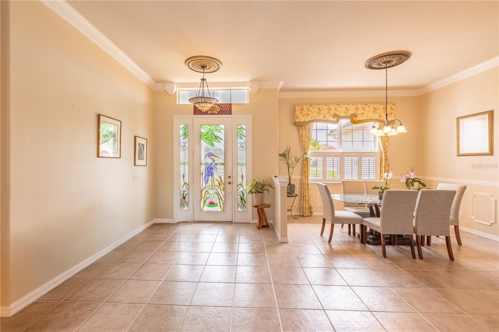 A dining area and entryway feature tile floors, a stained-glass front door, and pendant lighting — 1626 E GATE DANCER CIRCLE, INVERNESS, FL