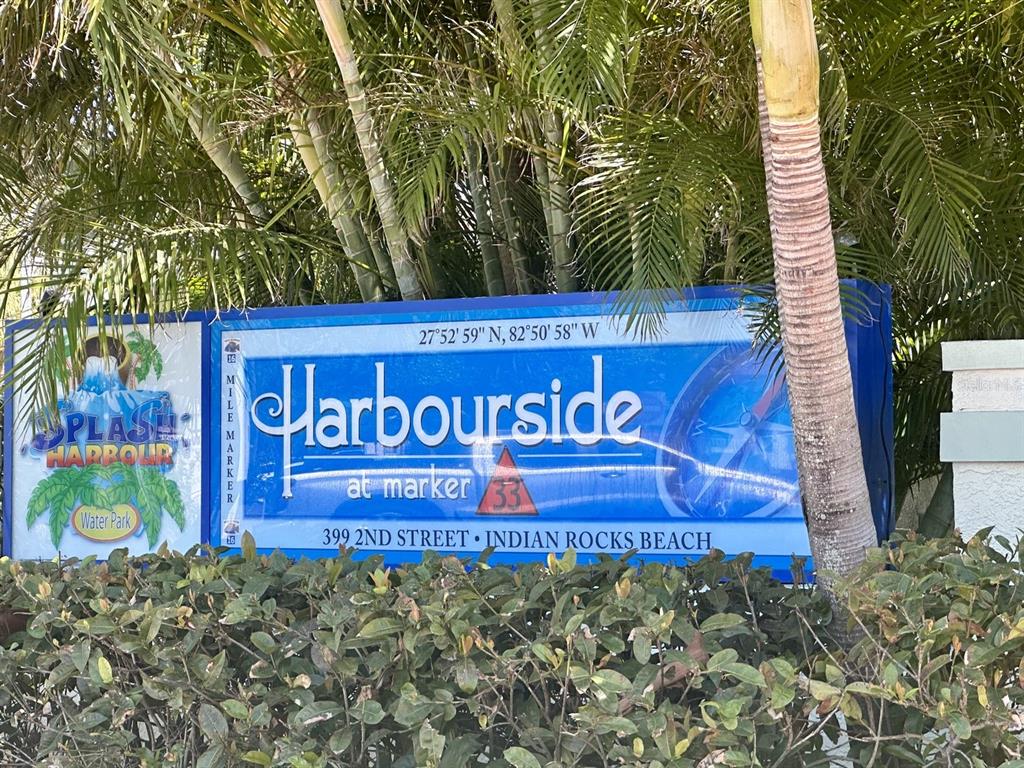 A blue sign for Harbourside at Marker 33 stands behind green bushes and palm trees — 399 2ND STREET UNIT 416, INDIAN ROCKS BEACH, FL