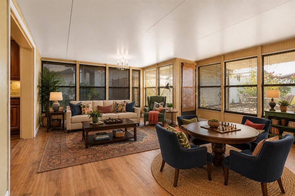 A sunroom with wood-look flooring, large windows with blinds, a sofa, and a dining table — 145 MAYFAIR COURT UNIT 145, SANFORD, FL