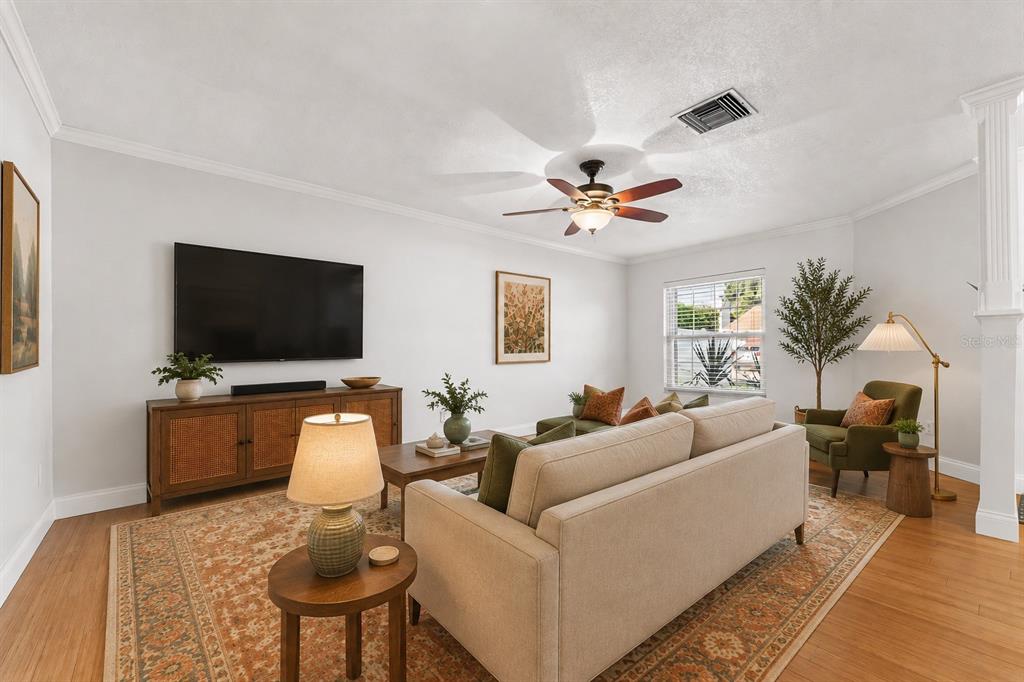 A living room features a beige sofa, a television on a wooden console, and hardwood floors — 145 MAYFAIR COURT UNIT 145, SANFORD, FL