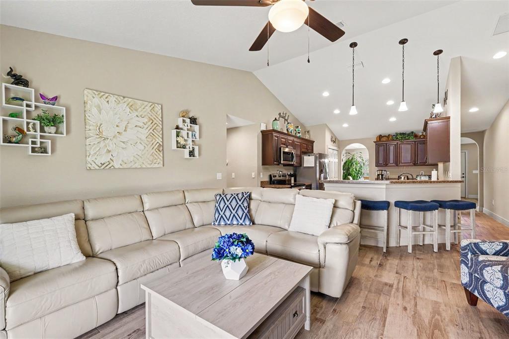 A living room with a beige sectional sofa, coffee table, and an open kitchen area — 4 MALAUKA RADIAL PASS, OCKLAWAHA, FL