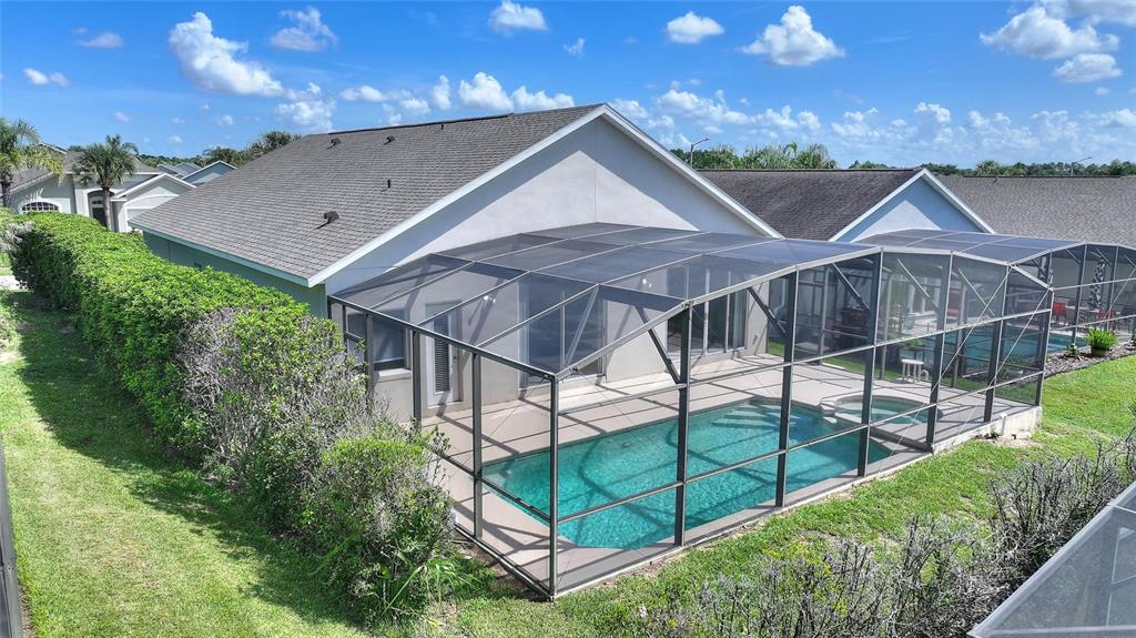 An aerial view shows a house with a screened-in pool and patio in the backyard — 16616 PALM SPRING DRIVE, CLERMONT, FL