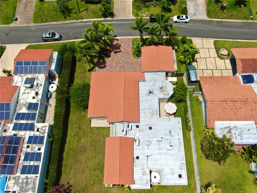 A modern house exterior features a wood-paneled garage door, a paved driveway, and palm trees — 302 CAMINO DE LOS CEDROS, DORADO, PR