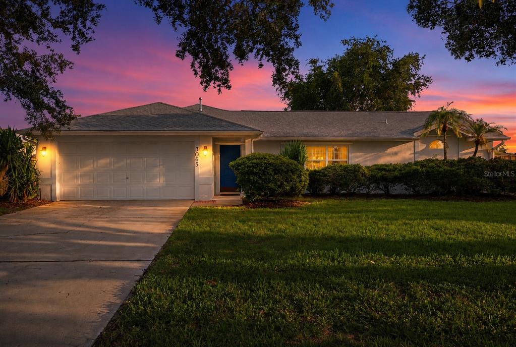 A single-story house with a white garage, blue front door, and a grassy front yard — 3065 PINEDA CROSSING DRIVE, MELBOURNE, FL