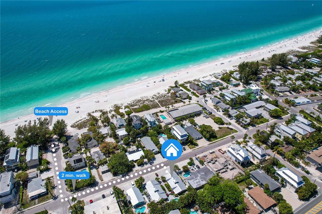 An aerial view shows a coastal neighborhood with a marked path to the beach — 3009 AVENUE E UNIT A, BRADENTON BEACH, FL