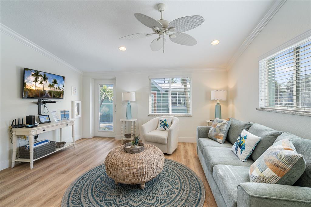 A living room features a sofa, armchair, round coffee table, and a ceiling fan — 3009 AVENUE E UNIT A, BRADENTON BEACH, FL
